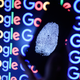 A thumbprint on a mobile phone in front of the Google logo.